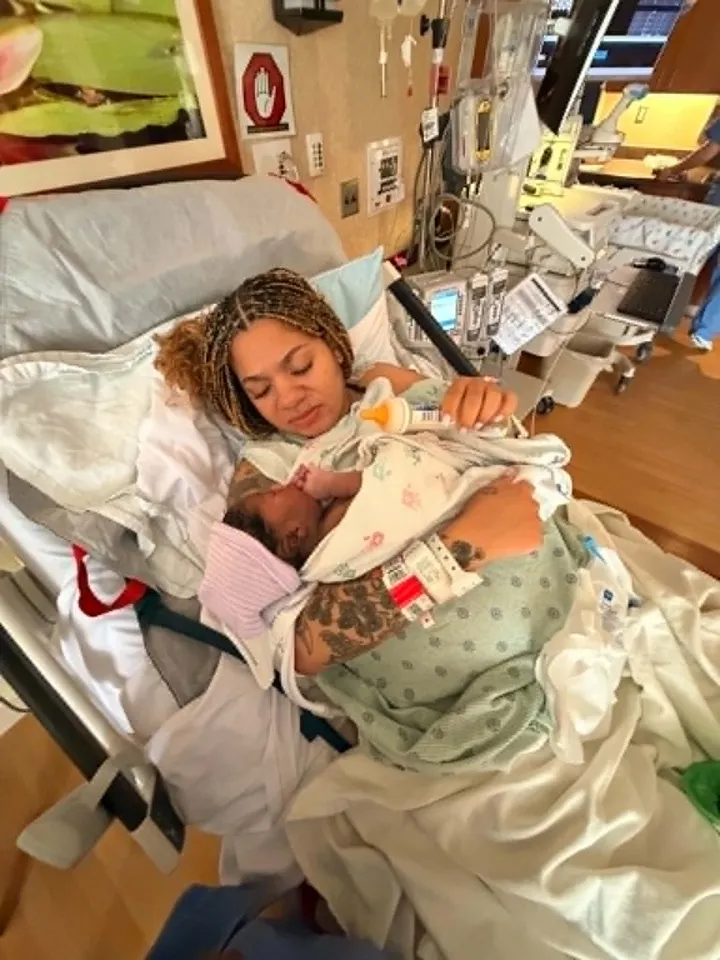 A mother holding her baby close